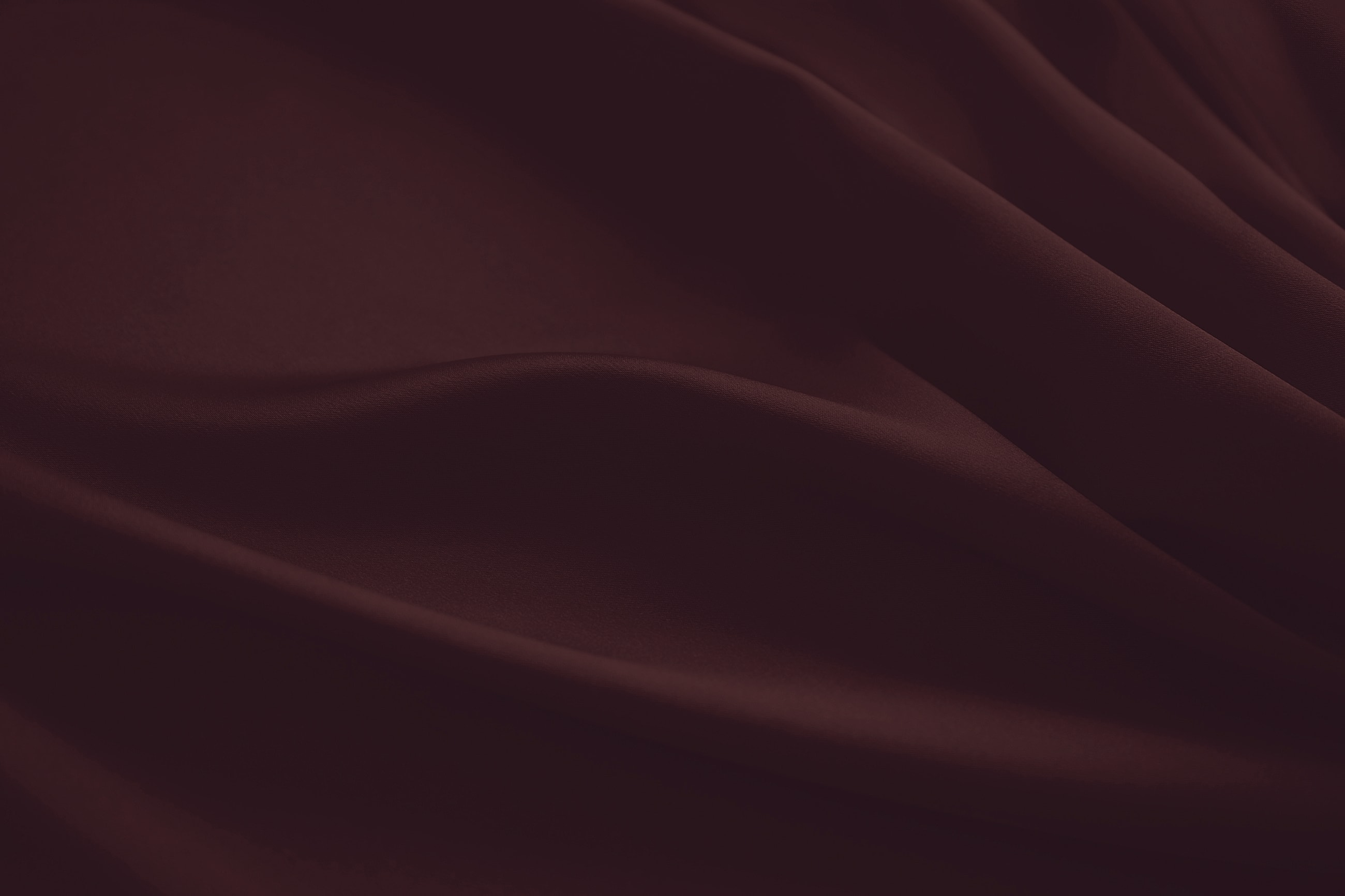 Burgundy fabric with soft, flowing texture.