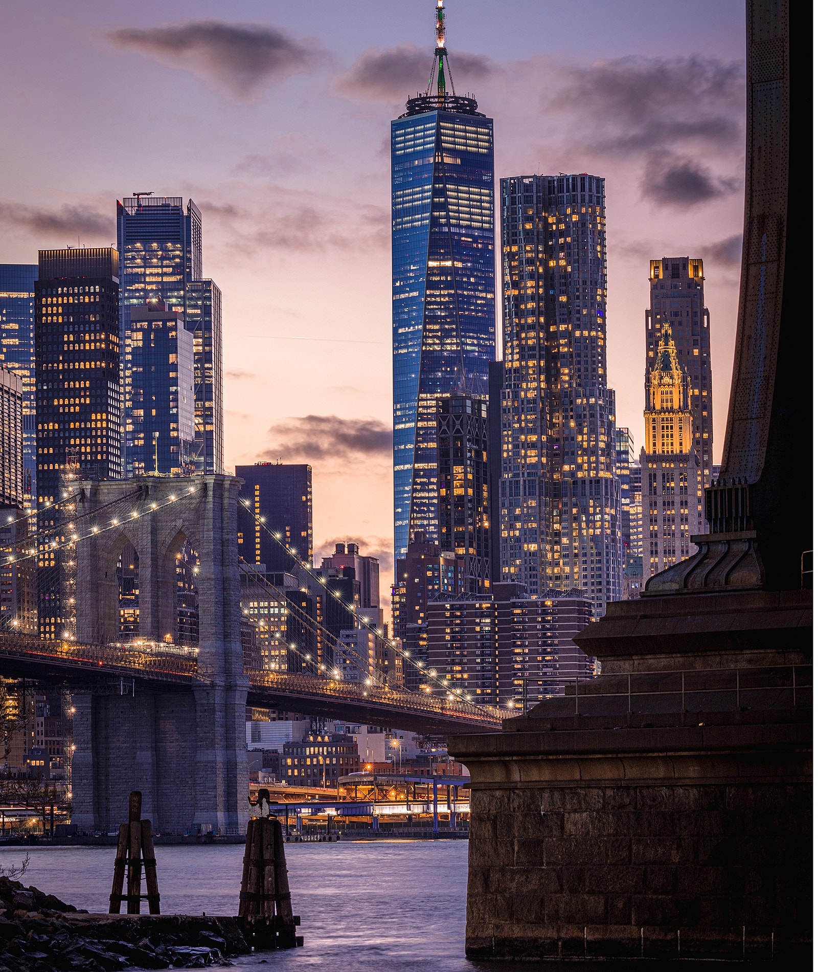 Brooklyn Bridge with Manhattan skyline at dusk.