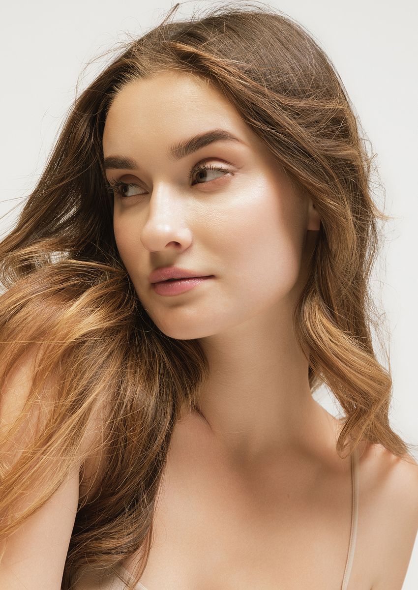 Woman with long hair against a neutral background.