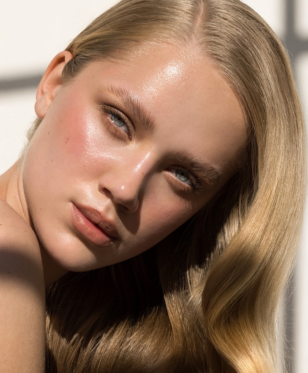 Portrait of a blonde woman with glowing skin and hair.