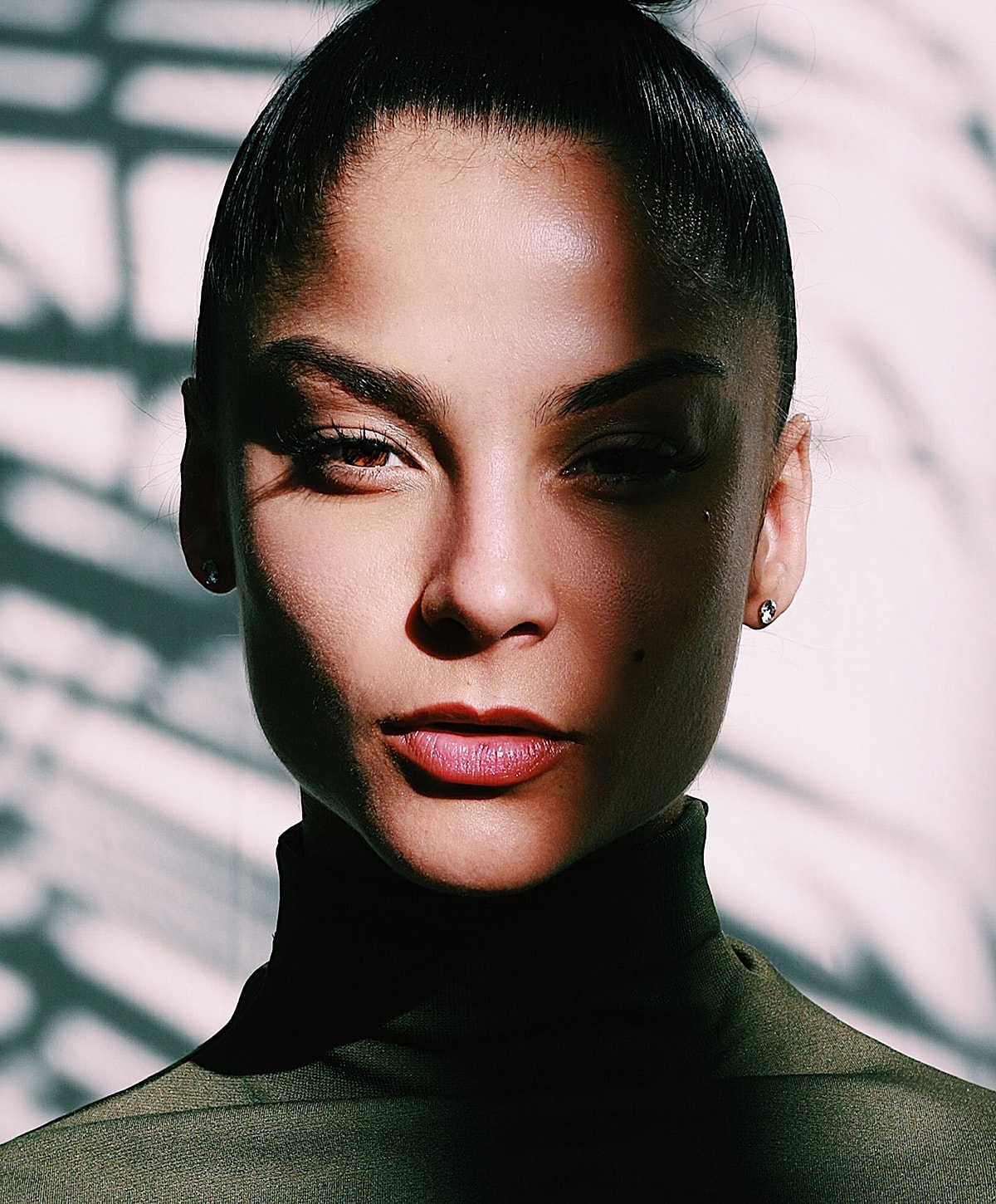 Close-up portrait with dramatic lighting and shadows.