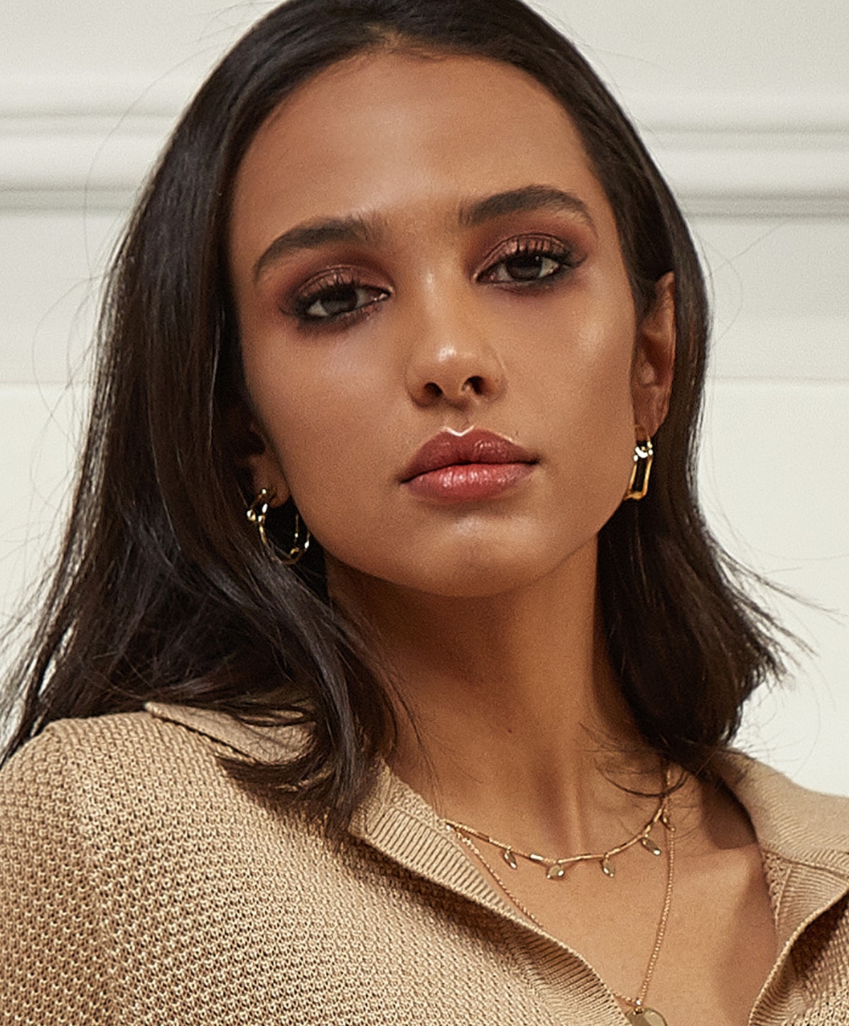 Portrait of a woman with dark hair and earrings.