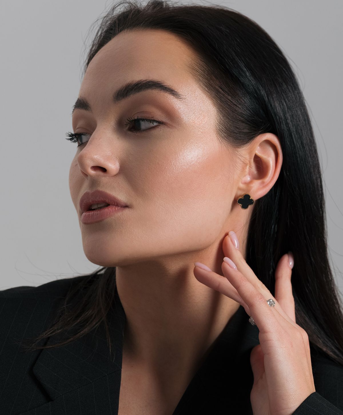 Model showcasing elegant jewelry and makeup.