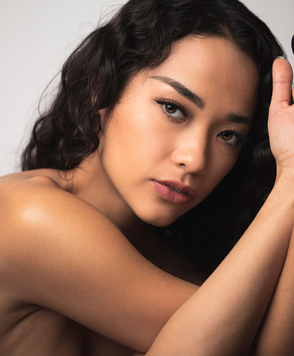 Close-up portrait of a woman with curly hair.