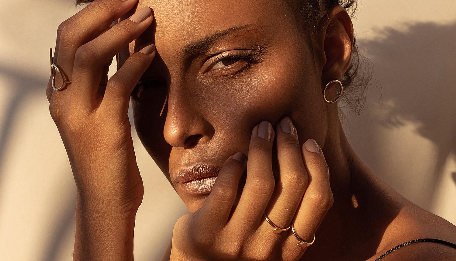 Portrait of a woman with radiant skin wearing gold jewelry