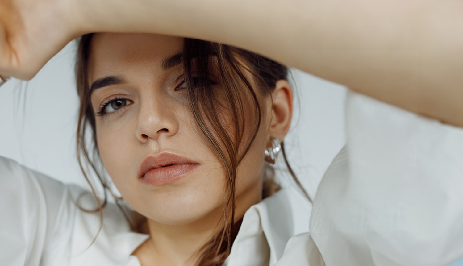 Person with closed eyes, gently holding face.