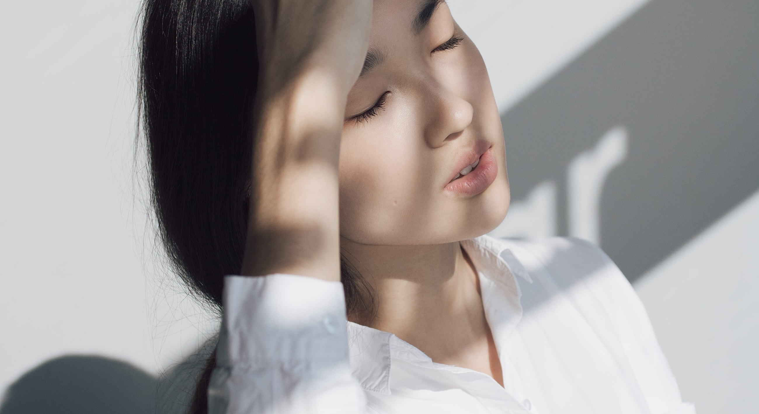 Woman with closed eyes in soft light.