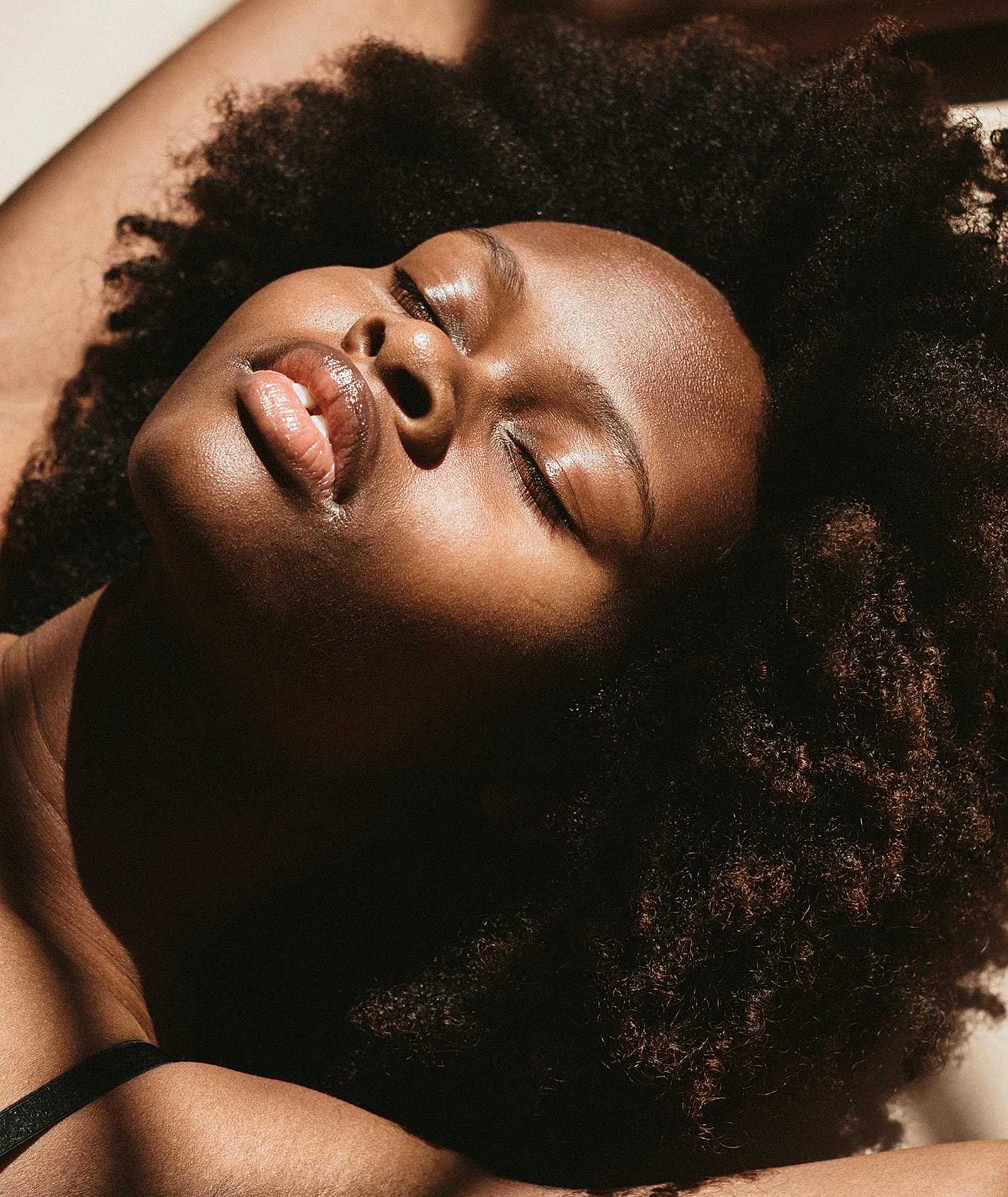 Person with natural hair relaxing in sunlight.